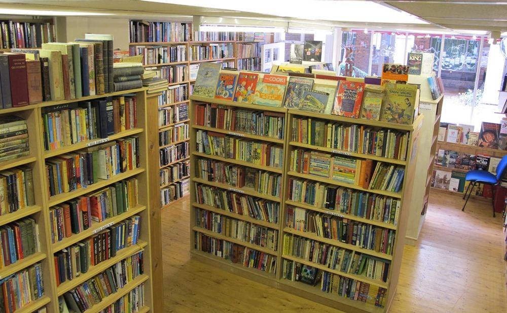 Inside Much More Books: pine shelves filled to the roof with secondhand books